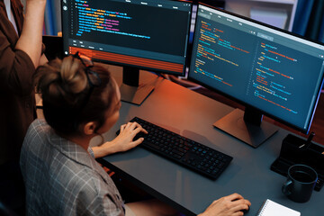 IT developers discussing with point to intelligent website development coder system running data...