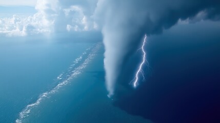 Majestic tornado touches ocean surface under striking lightning in dramatic sky