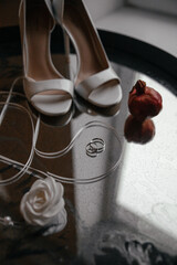 Wedding essentials beautifully arranged, featuring elegant white heels, a decorative white rose,...