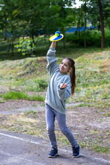 Cheerful child enjoying playing outdoors with ball and racket.