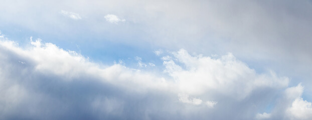 A low-angle view of a cloudy sky with sunlight breaking through the upper clouds