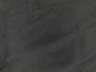 Dark denim fabric texture with subtle diagonal weave pattern, showing fine detail in the threads....