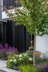 Fototapeta premium A vibrant garden filled with blooming flowers beautifully complements the sleek, modern architecture of a contemporary home, all illuminated by the bright daylight
