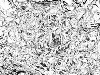 Crinkled reflective surface with intricate creases and folds, showcasing a textured and chaotic pattern. Abstract shapes create a shimmering effect across the entire expanse