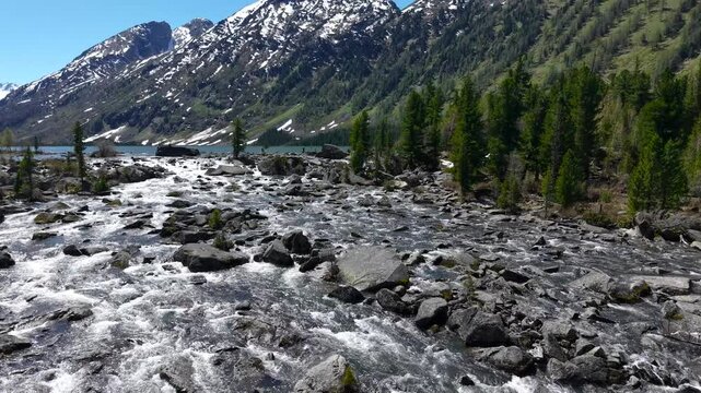 Multinsky lakes of the Altai Republic. Beautiful high-mountain lakes surrounded by mountains, cinematic 4k views. Rapids of water between the second and first lakes, drone flight.