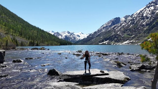 Woman hiker at mountain lake. Woman on the shore of Multinskoye Lake in Altai Mountains, hiking in the mountains