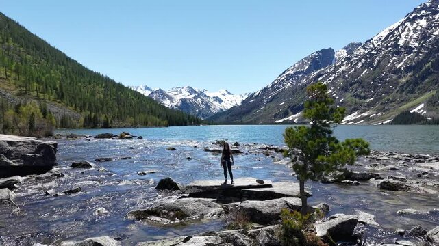 Woman hiker at mountain lake. Woman on the shore of Multinskoye Lake in Altai Mountains, hiking in the mountains