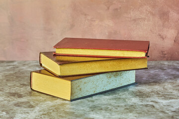 Stack of books on a marble table. Collection of different books. Hardcover books for reading. Book reading concept.