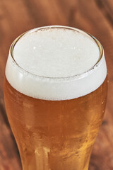 A glass of ice-cold golden beer in close-up, ideal for attracting beer lovers.