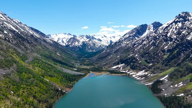 Cinematic views of a mountain lake with high mountains. Multinsky lakes are high-mountain lakes in the Altai Mountains. View from a great height of a lake surrounded by mountains 4k