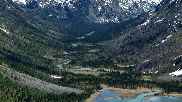 Cinematic views of a mountain lake with high mountains. Multinsky lakes are high-mountain lakes in the Altai Mountains. View from a great height of a lake surrounded by mountains 4k