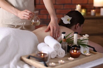 Woman receiving back massage with oil in spa salon