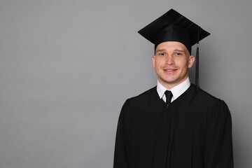 Happy student after graduation on grey background. Space for text