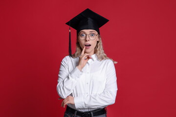 Emotional student after graduation on red background