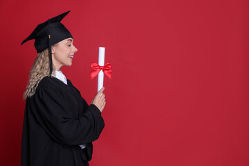 Happy student with diploma after graduation on red background. Space for text