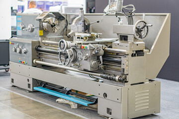 Industrial setting with metalworking machinery, possibly a CNC lathe Silver and blue metallic device with detailed components in an indoor environment under even lighting No people present Realist