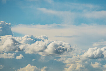 Close-up view of towering, varied cumulus clouds in a sky transitioning from pale blue to white No human or specific objects identified Soft, even lighting casting gentle shadows Realistic style,