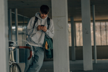 young underground man with mobile phone and vintage bicycle, urban scene