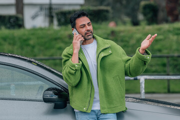 bearded man outdoors with mobile phone in the car