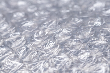 Bubble wrap macro photo with selective focus. It is a pliable transparent plastic material with bubbles of air used for packing fragile items. Close-up texture