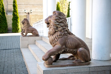 Two lion statues at the entrance of a building with columns, symbolizing strength and grandeur