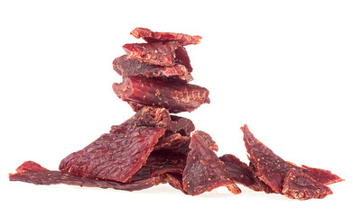 Portion of spicy beef jerky isolated on white background. Dried pieces of beef meet.