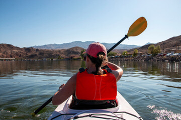 Kayaker Paddling on Calm Water Surrounded by Mountains