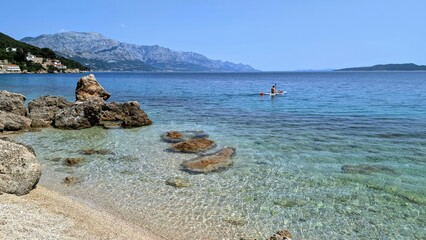 Person Paddling in Blue Adriatic Sea, Mimice, Croatia, Tranquil Beach Scene with Clear Water and...