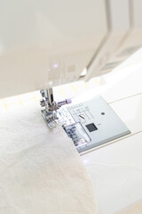 sewing machine with a cloth under a steel needle. manufacture of clothing. a household or industrial sewing machine. tailor, couturier. work on sewing designer clothes.