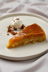 A mouthwatering piece of baklava, glistening with syrup, sits elegantly on a white plate
