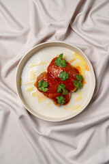 A plated serving of enchiladas showcases a rich red sauce and bright cilantro on a soft, textured background, celebrating culinary artistry at mealtime