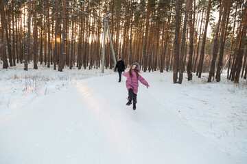 Father and daughter having fun with snow tube in the forest