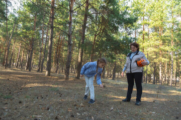 Obraz premium Grandmother and granddaughter walking in forest holding sports ball on sunny day