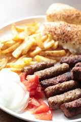 A balkan traditional meatball dish cevapi, cevapcici  on wooden table in close-up	