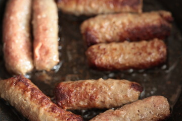 A balkan traditional meatball dish cevapi, cevapcici  on wooden table in close-up	