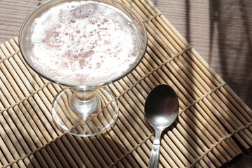 Strawberry pink pudding in glass mug on wooden table close up