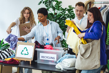 Young woman brings old clothes for recycling, charity, donation. Volunteers sorting textile to prevent pollution, environment protection. Second hand shopping. Eco conscious responsible lifestyle. 