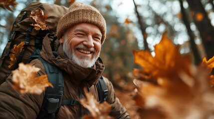 A joyful elderly man smiles brightly amidst a backdrop of colorful autumn leaves, representing appreciation for nature and the simple joys of life in outdoor adventures.