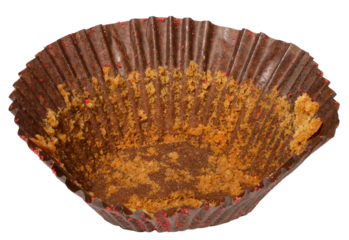 Empty brown paper cupcake or muffin tin with chocolate residue, isolated background