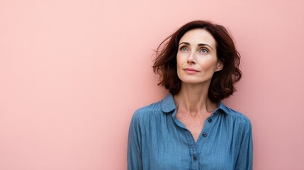 Contemplative Woman with Short Hair Against a Soft Pink Background