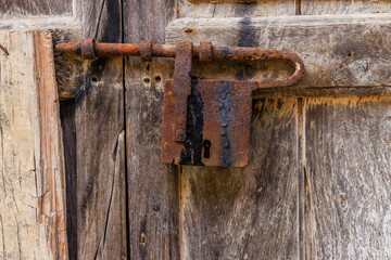 Rusted antique lock on a weathered wood door. Scilla, Italy.