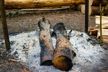 Fire pit with ashes and charred wood on the territory of a camping site