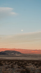 Full Moon Rising Over Desert Mountains at Sunset — Minimalist Landscape with Soft Gradient Sky and Warm Golden Hour Light on Rugged Terrain, Southwest USA Nature Scene for Travel and Fine Art Photogra