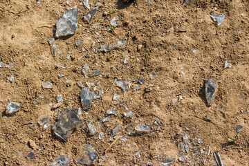 Gray glass shards lying on brown ground