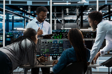 Engineering team programming in AI data center housing advanced equipment used for machine learning...