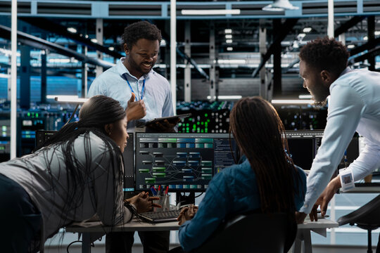 Engineering team programming in AI data center housing advanced equipment used for machine learning training. Server farm workers running code on PC to upgrade artificial intelligence systems - Powered by Adobe