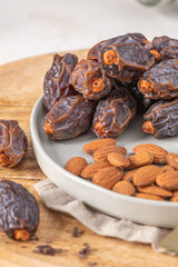Medjool dates and almonds on a plate, showcasing a healthy snack option with rich textures and natural colors, perfect for nutritious eating and culinary inspiration