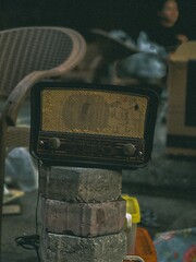 Cairo, Egypt – February 15, 2025: Close-up of a vintage radio placed on stacked bricks at a local...