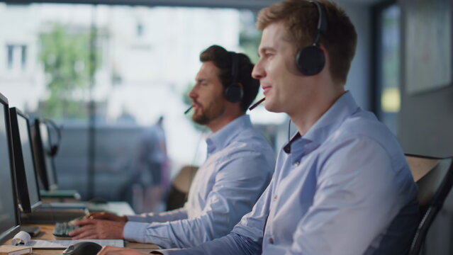 Customer service team working at modern call center closeup. Helpdesk staff