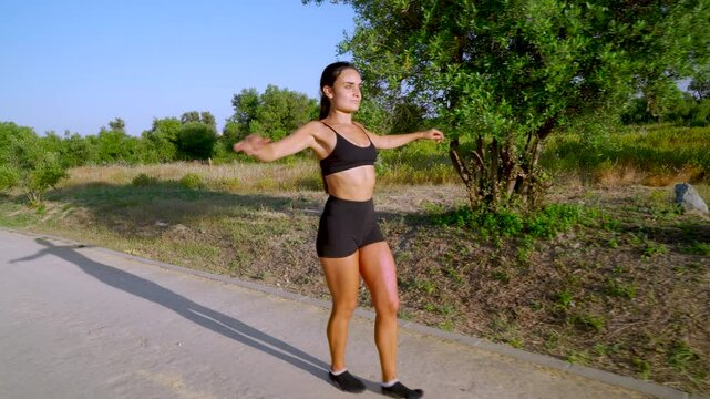 Mujer joven deportista haciendo ejercicios en el parque un  d&iacute;a soleado con cielo azul.